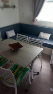 una mesa y sillas en una habitación con sofá en mobil home le castellas Bertrand /stehlin, en Sète
