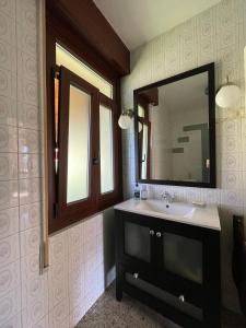 La salle de bains est pourvue d'un lavabo et d'un miroir. dans l'établissement CHALET A BARROSA - PONTEDEUME, à Pontedeume