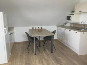 a small kitchen with a table and two chairs at Le Gîte des Fèves in Lecelles