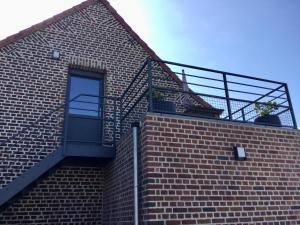 a staircase on the side of a brick building at Le Gîte des Fèves in Lecelles