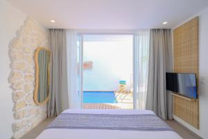 1 dormitorio con 1 cama, TV y balcón en Villa Hanara - Unique 2BR Mediterranean, en Uluwatu