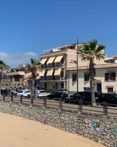 un edificio con palmeras frente a una calle en Marger Apartments, en Santa Maria di Castellabate