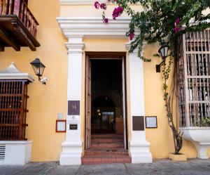 a yellow building with a door and stairs at Nacar Hotel Cartagena, Curio Collection by Hilton in Cartagena de Indias