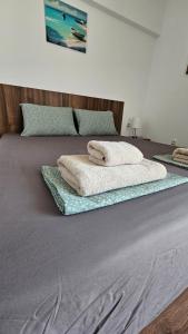 two towels sitting on top of a bed at Sea and Sand Apartment Greenn Life in Sozopol