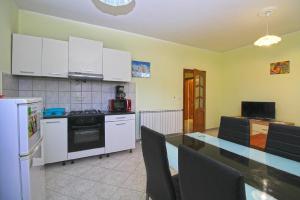 uma cozinha com armários brancos e uma mesa com cadeiras em Ferienwohnung für 4 Personen ca 50 qm in Pula-Fondole, Istrien Istrische Riviera - b61749 em Štinjan