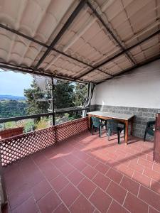 patio con mesa y sillas en el balcón en Appartamento in collina a 15 minuti dal mare, en Riparbella