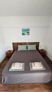 a bedroom with a large bed with two towels on it at Sea and Sand Apartment Greenn Life in Sozopol