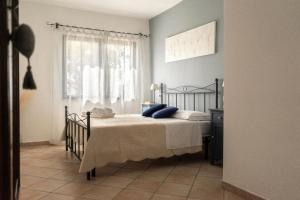 een slaapkamer met een bed met blauwe kussens en een raam bij Ferienwohnung für 2 Personen 2 Kinder ca 50 qm in Rosignano Marittimo, Toskana Etruskische Küste in Rosignano Marittimo