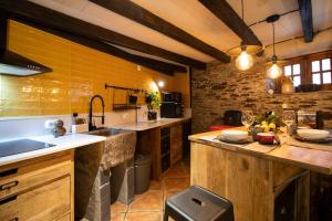 uma grande cozinha com paredes amarelas e balcões de madeira em Casa da Serra - Mountain Home em Arganil