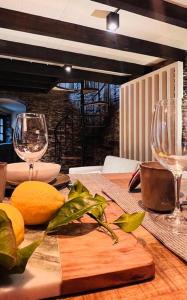 una mesa con dos copas de vino y naranjas. en Casa da Serra - Mountain Home, en Arganil