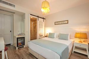 a bedroom with a large white bed and a fireplace at AlaBora Hotel in Alacati