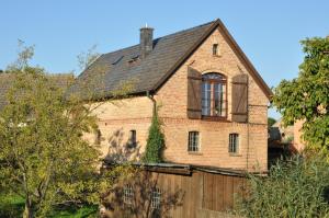 uma casa de tijolos com uma janela e uma cerca de madeira em Ferienhaus Melzow em Melzow