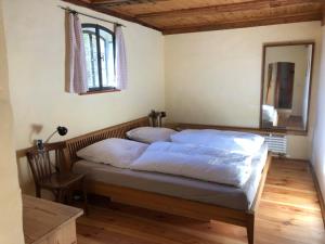 um quarto com uma cama com lençóis brancos e um espelho em Ferienhaus Melzow em Melzow