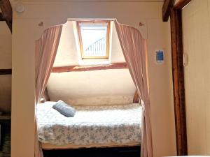 a small bed in a room with a window at Y Beudy Llangrannog in Llangranog