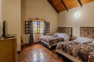 a bedroom with two beds and a tv and a window at Casa familiar en la colonia Tovar in El Tigre
