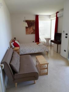 ein Wohnzimmer mit einem Bett und einem Sofa in der Unterkunft Valle dell Idro Otranto in Casamassella