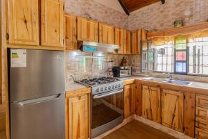 El Tigre的住宿－Casa familiar en la colonia Tovar，厨房配有木制橱柜和不锈钢冰箱。