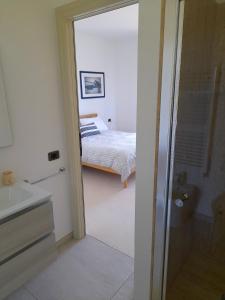 ein Schlafzimmer mit einem Bett und ein Badezimmer mit einer Dusche in der Unterkunft Valle dell Idro Otranto in Casamassella