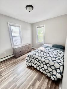 a bedroom with a bed and two windows at Northern Delight in Bloomfield