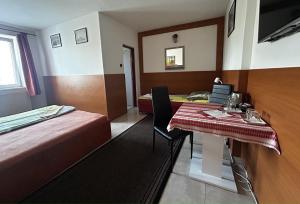 pokój hotelowy z łóżkiem, stołem i krzesłami w obiekcie Penzión Rozália w Koszycach