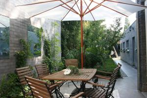 - une table et des chaises en bois avec un parasol sur la terrasse dans l'établissement Casa Lucinda, à Gand