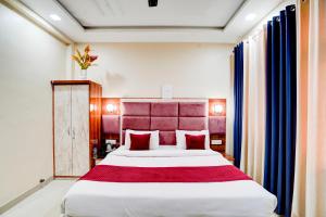 a bedroom with a large bed with a red headboard at Yoga Homestay in Agra