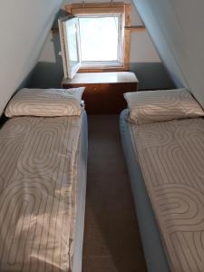 two beds in a room with a window at Life water small house in Budapest