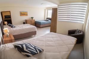 um quarto com 2 camas, um sofá e uma janela em Kawsay Apart em La Paz