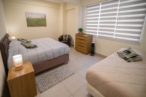 1 dormitorio con 2 camas y ventana en Kawsay Apart, en La Paz
