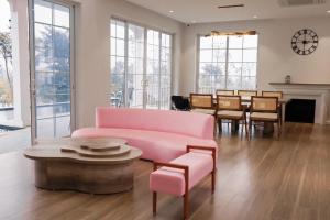 a living room with a pink couch and a table at Lucia Villa - Melorita Hòa Lạc in Hanoi