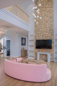 a living room with a fireplace and a pink couch at Lucia Villa - Melorita Hòa Lạc in Hanoi