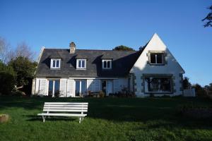 a white bench sitting in front of a house at Les pieds dans l'eau in Saint Malo