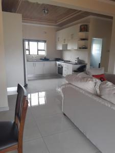 a large white kitchen with a couch in a room at PHIL M AND PARTNERS ESTATES. in Manzini