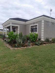 a small house with a green lawn in front of it at PHIL M AND PARTNERS ESTATES. in Manzini