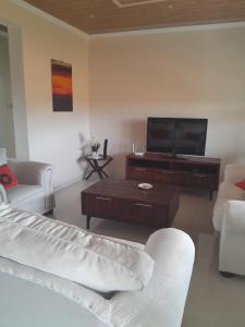 a living room with a couch and a flat screen tv at PHIL M AND PARTNERS ESTATES. in Manzini