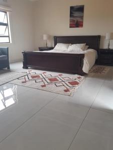- une chambre avec un lit et un tapis au sol dans l'établissement PHIL M AND PARTNERS ESTATES., à Manzini