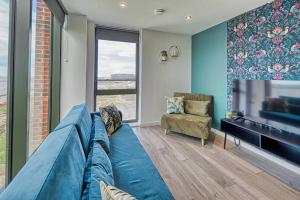 een woonkamer met een blauwe bank en een televisie bij Ultimate Escape - Great View in Liverpool