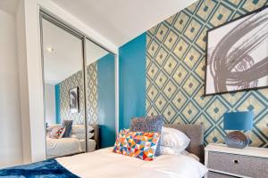 een slaapkamer met blauwe muren en een spiegel bij Ultimate Escape - Great View in Liverpool