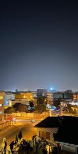 une ville de nuit avec une rue et des bâtiments dans l'établissement Residence Roume Abidjan Plateau, à Abidjan