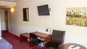 Cette chambre comprend un bureau, deux chaises et un lit. dans l'établissement A Hotels Roskilde, à Hedehusene