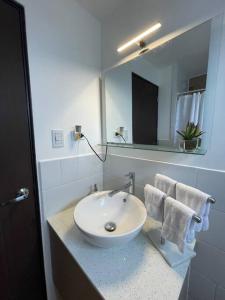 a bathroom with a white sink and a mirror at Apartamento en Quetzaltenango in Quetzaltenango