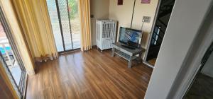 sala de estar con TV y suelo de madera en Skyview Villa Udaipur, en Udaipur