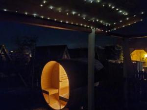 un patio con luci e una camera con tavolo di Idyllisches Ferienhaus am See mit Fass-Sauna, Liegewiese und Grill im Bayer Wald a Waldkirchen