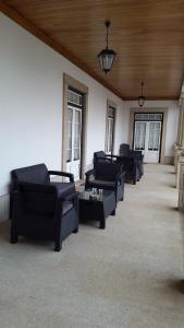 a living room with black couches and a table at Casa do Fontão in Amarante