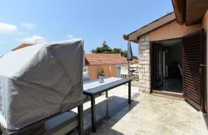 a covered table on the balcony of a house at Ferienwohnung für 4 Personen ca 85 qm in Fažana, Istrien Istrische Riviera in Fažana +14 photos