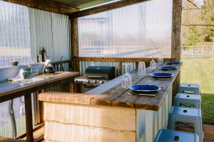 an outdoor kitchen with a large wooden bar with blue dishes on it at Rosgarron Safari Canvas Lodge Glorious Glamping in Magherafelt +21 photos