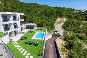 z góry widok na dom z basenem i drogą w obiekcie Luxury Villa Amataa - 38m2 pool, jacuzzi, sauna w mieście Mošćenička Draga