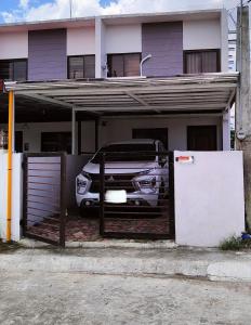 un coche aparcado en un garaje frente a una casa en RCA Transient house in San Jose del Monte, en Muzon