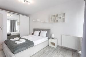 1 dormitorio blanco con 1 cama grande y espejo en Ferienwohnung am Meer, Urlaub auf der Insel Usedom, Apartment Flotylla 13, en Świnoujście