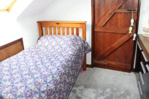 a bedroom with a bed and a wooden door at The Beach House in Newry